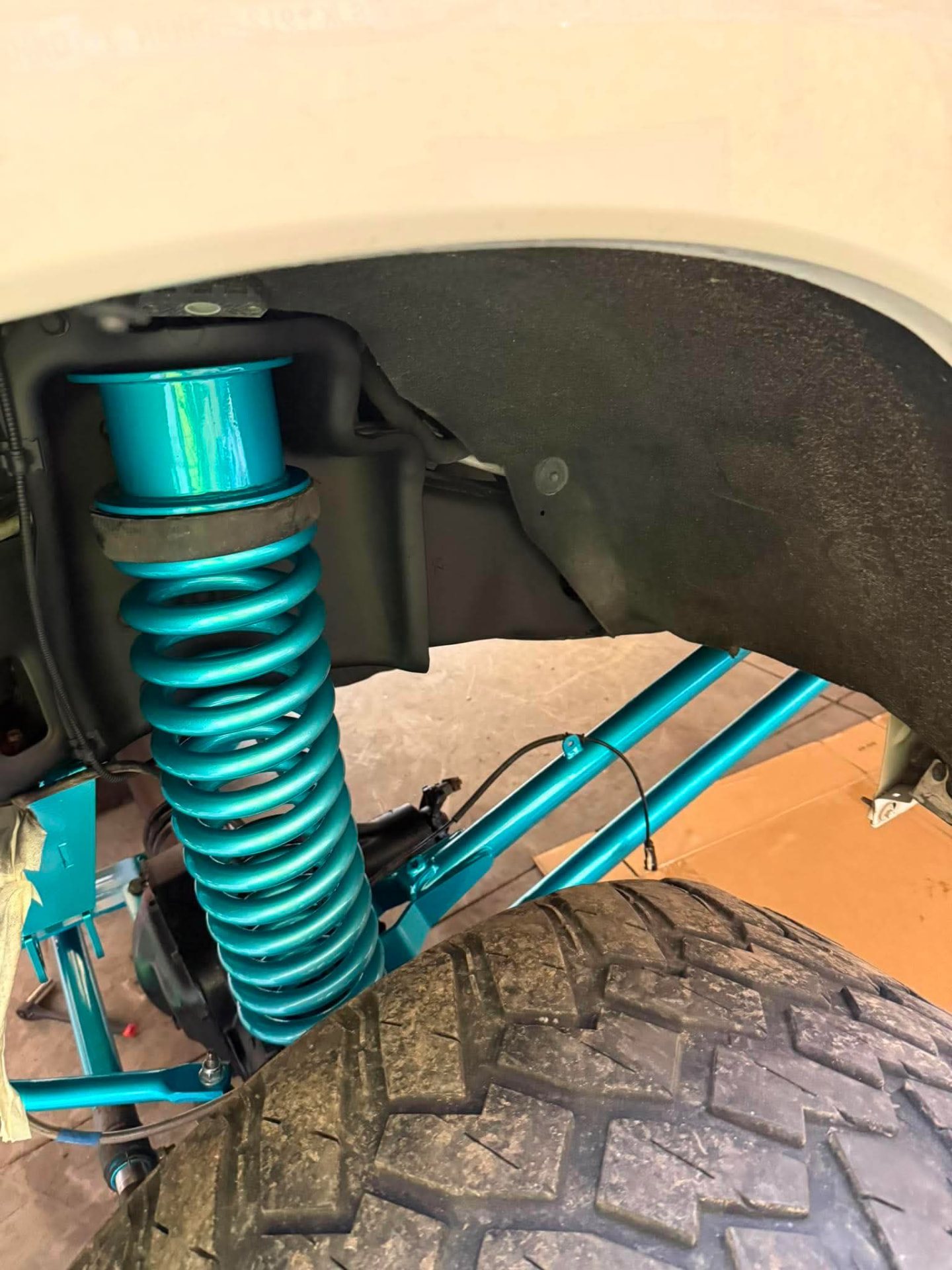 Teal powder-coated suspension parts by Nipper's Powder Coating